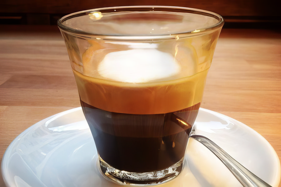 Šviežiai paruoštas Espresso Macchiato puodelis su pieno putos akcentu